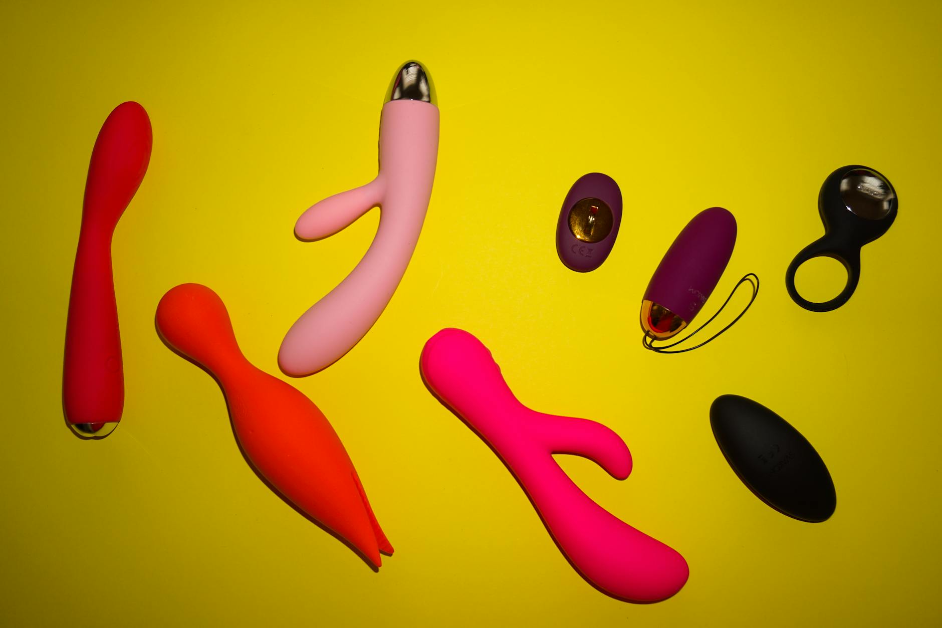 Vibrant collection of lemon vibrators and sex toys arranged on a bright yellow surface