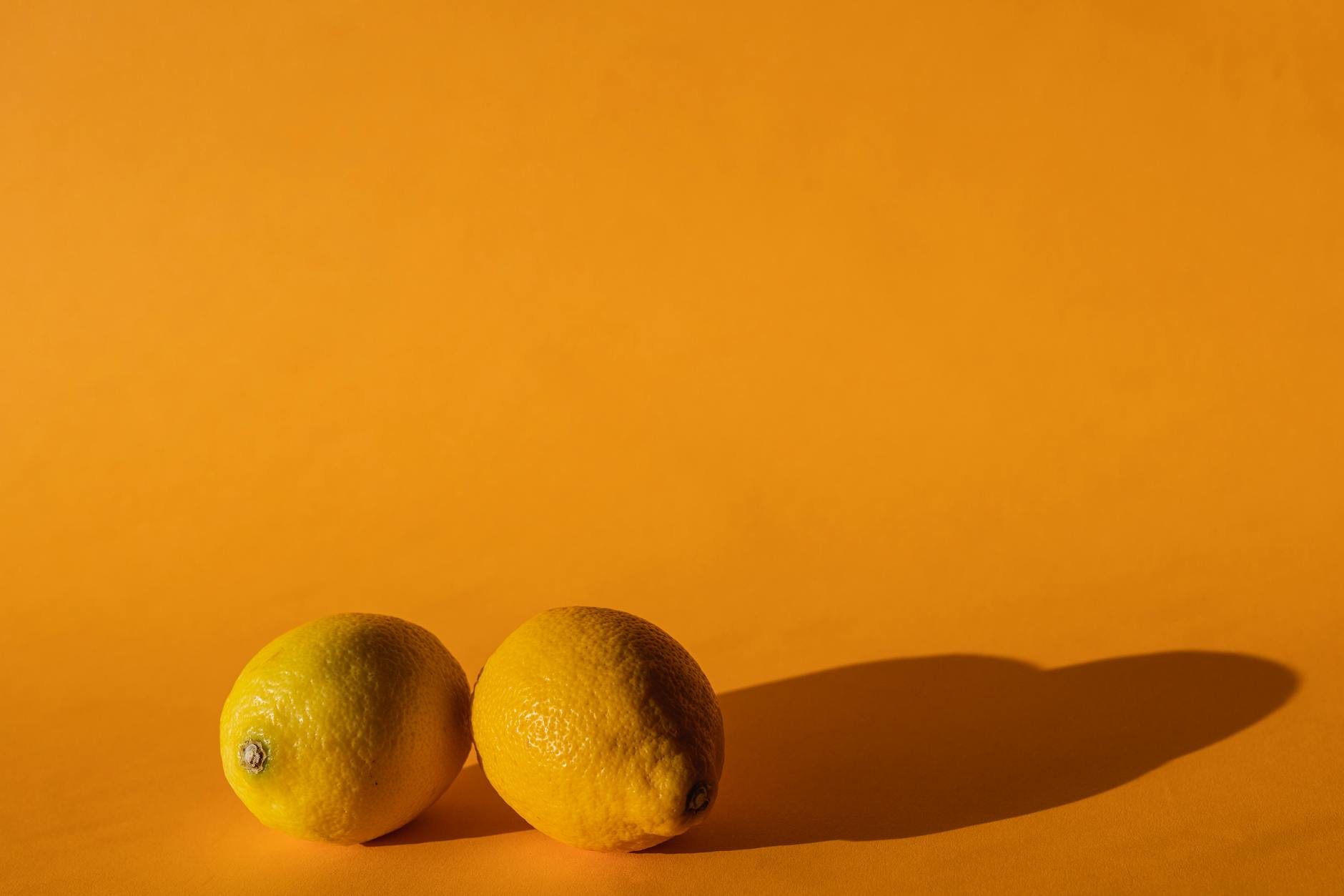 Bright vivid lemons on yellow background in modern studio daylight